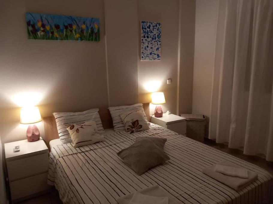 una camera da letto con un letto grande con due lampade di "Sea breeze and olives" apartment a Karianí