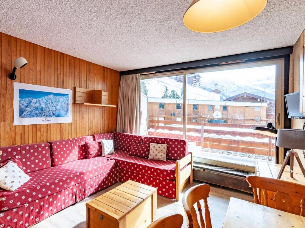 - un salon avec un canapé rouge et une grande fenêtre dans l'établissement Résidence Ruitor - RUITOR 103 MAE-3961, à Les Allues