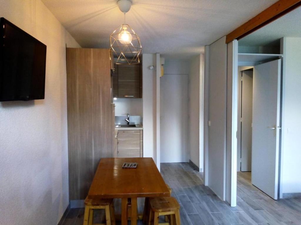 une salle à manger avec une table en bois et une cuisine dans l'établissement Résidence Boulevard - BOULEVARD B04 MAE-3991, à Les Allues