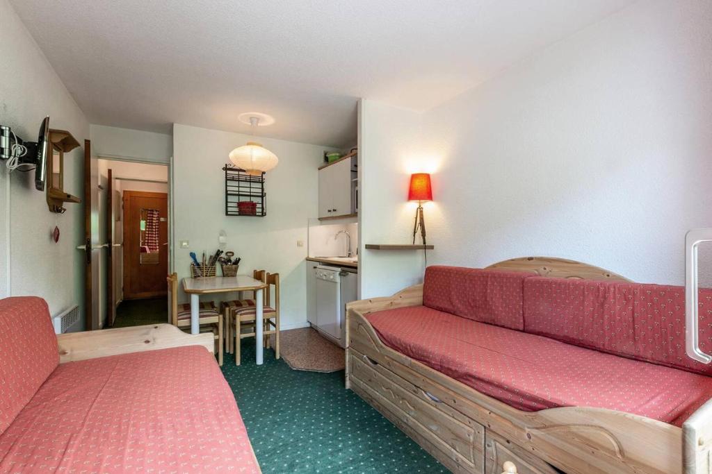 un salon avec un canapé rouge et une cuisine dans l'établissement Résidence Pralin - PRALIN 716 MAE-4031, à Les Allues