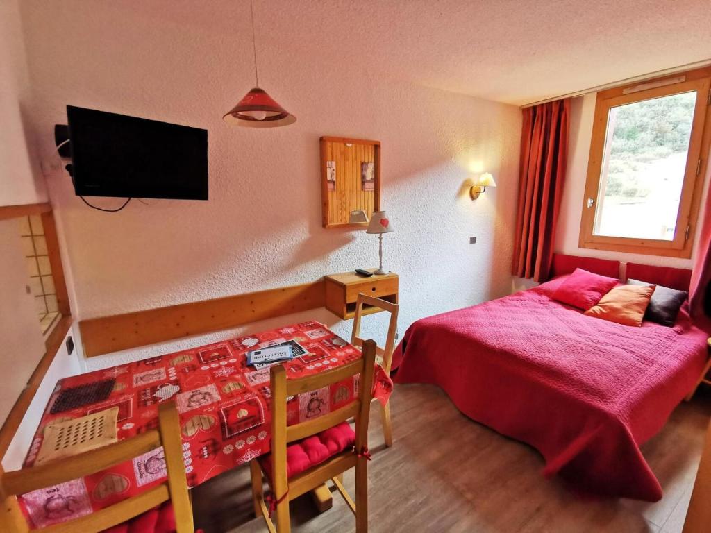 une chambre avec un lit et une télévision au mur dans l'établissement Résidence Candide - CANDIDE C12 MAE-4061, à Les Allues