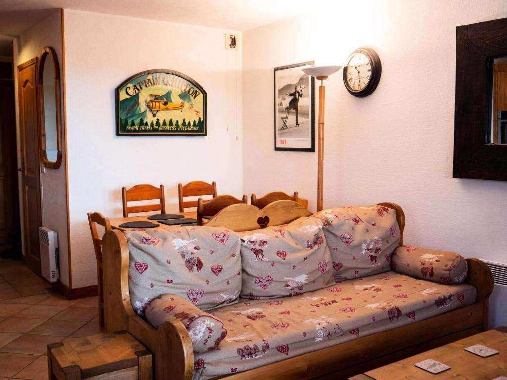 un salon avec un canapé et une horloge au mur dans l'établissement Résidence Alpages D - ALPAGES D4 MAE-4151, à Les Allues