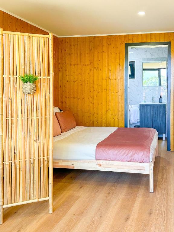 um quarto com uma cama com uma parede de madeira em Bungalow Bétula - Pichoses Camping - Gerês em Rio Caldo