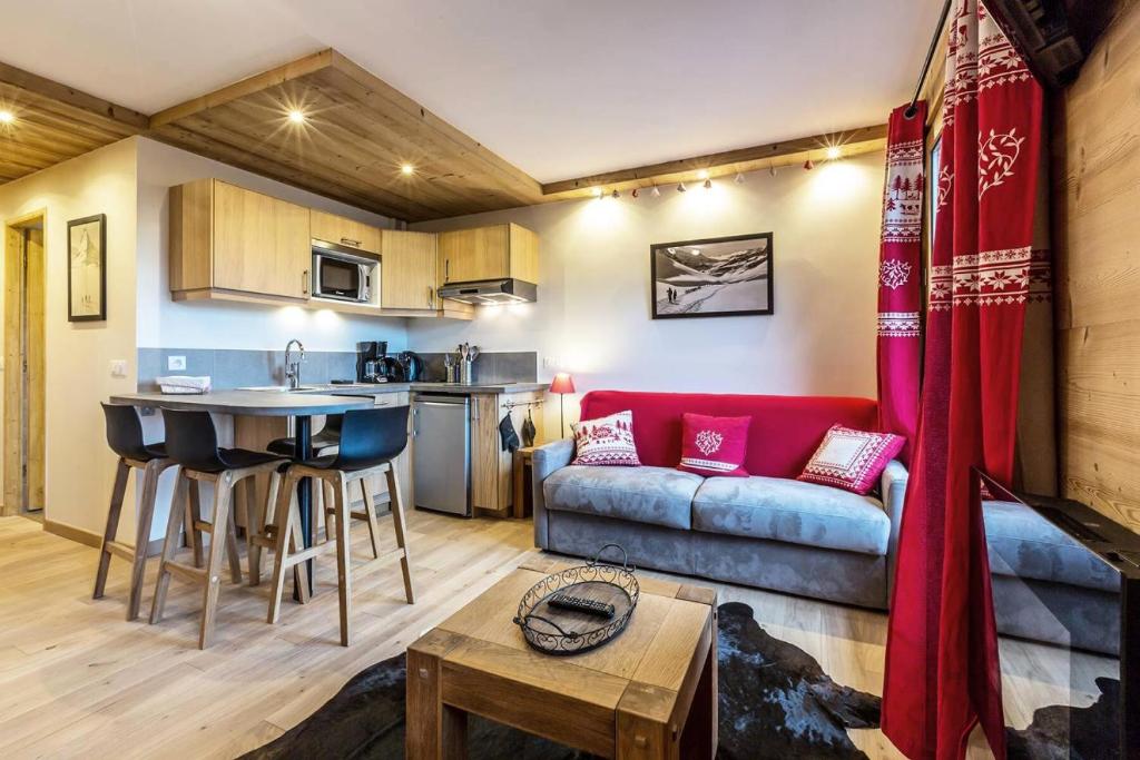 un salon et une cuisine avec un canapé et une table dans l'établissement Résidence Ruitor - RUITOR 113 MAE-4231, à Les Allues
