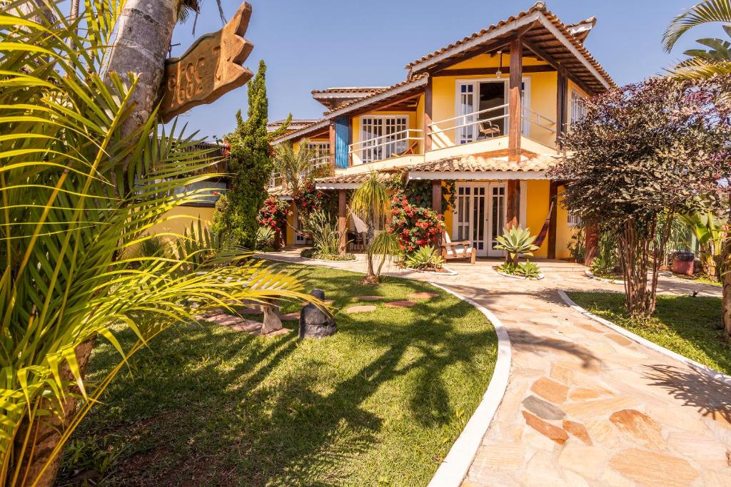 a house with a garden in front of it at Pousada Bonns Ventos in Ilhabela