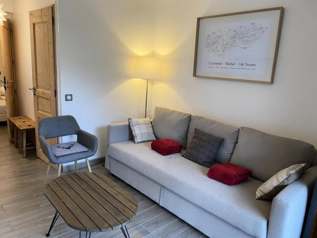 un salon avec un canapé et une chaise dans l'établissement Résidence Alpinea - ALPINEA A4 MAE-4371, à Les Allues