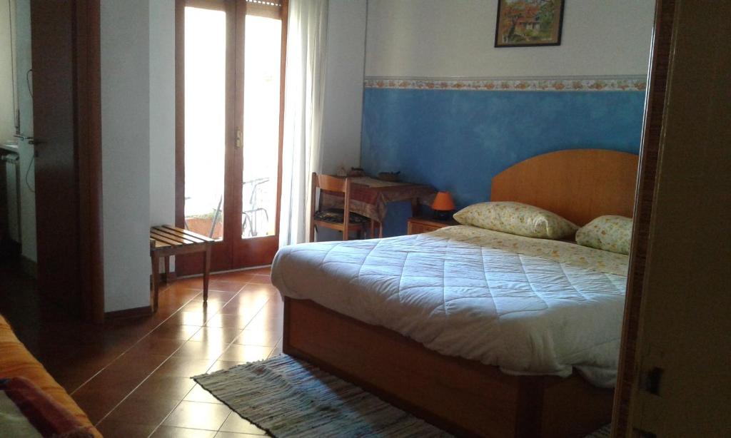 1 dormitorio con 1 cama con pared azul en The Dolphins Guest House, en Taormina