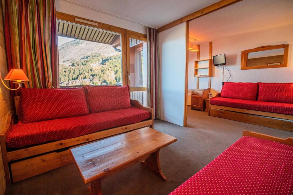 - un salon avec un canapé rouge et une fenêtre dans l'établissement Résidence Portail G - PORTAIL 73 MAE-5911, à Valmorel