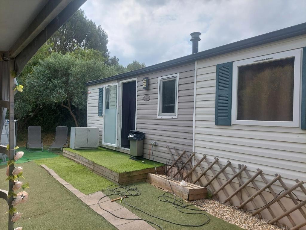 une petite maison avec une cour dans l'établissement Charmant Mobil home avec piscine privative, à Gémenos