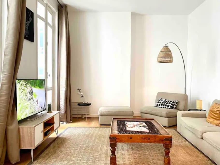 un salon avec un canapé et une télévision dans l'établissement Champs Elysées, à Paris