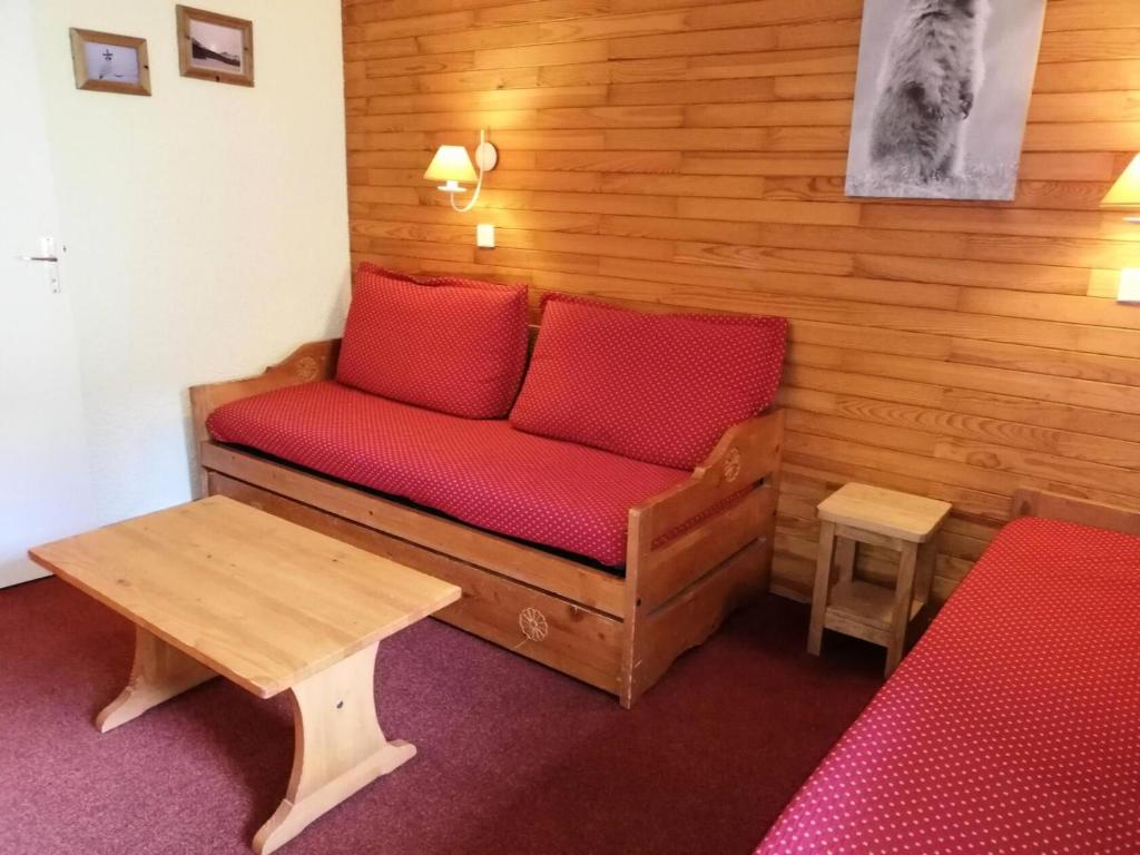 - un canapé avec des oreillers rouges dans l'établissement Résidence Lauzes G - LAUZES 24 MAE-6031, à Valmorel