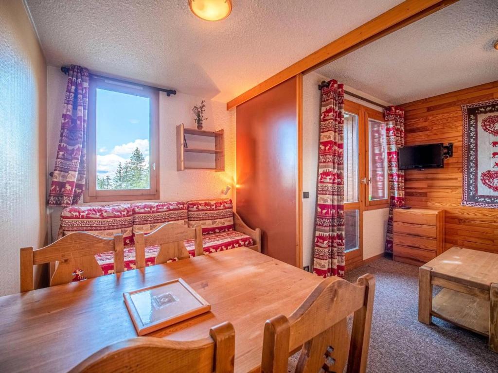 une salle à manger avec une table en bois et une fenêtre dans l'établissement Résidence Gollet G - GOLLET 32 MAE-6101, à Valmorel
