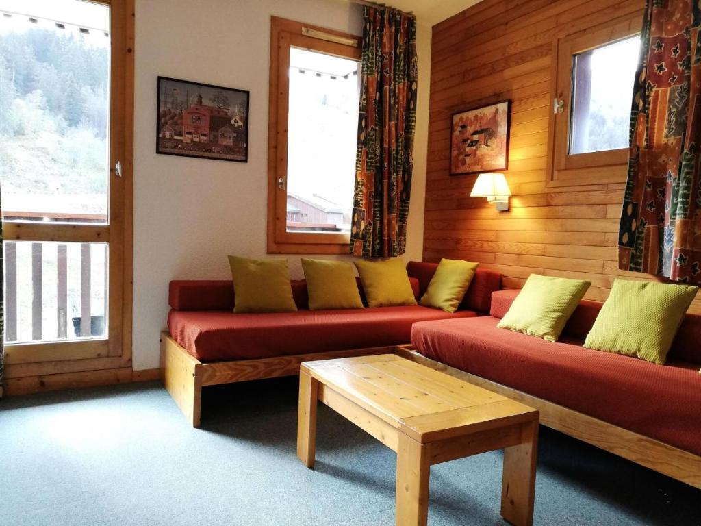 un salon avec deux canapés rouges et une table dans l'établissement Résidence Lauzes G - LAUZES 55 MAE-6201, à Valmorel