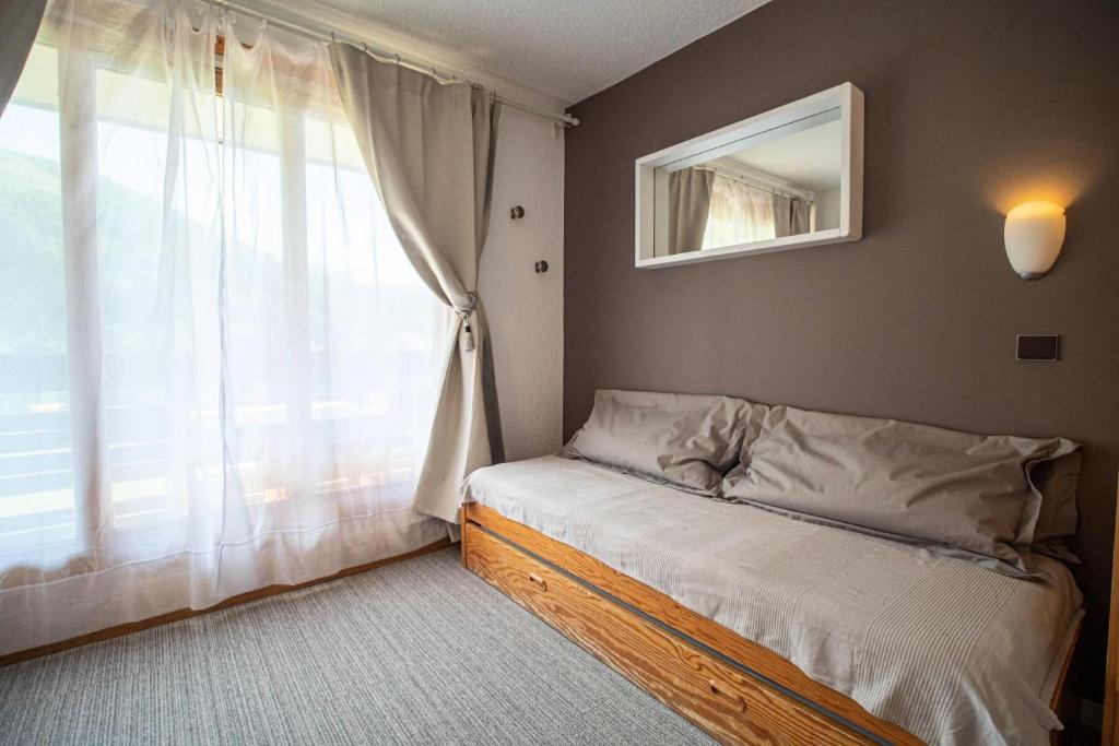 une petite chambre avec un lit et une fenêtre dans l'établissement Résidence Cristallin G - CRISTALLIN 13 MAE-6251, à Valmorel