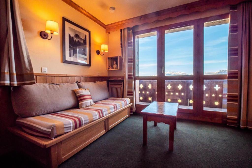 un salon avec un canapé et une fenêtre dans l'établissement Résidence Valeriane G - VALERIANE 220 MAE-6271, à Valmorel