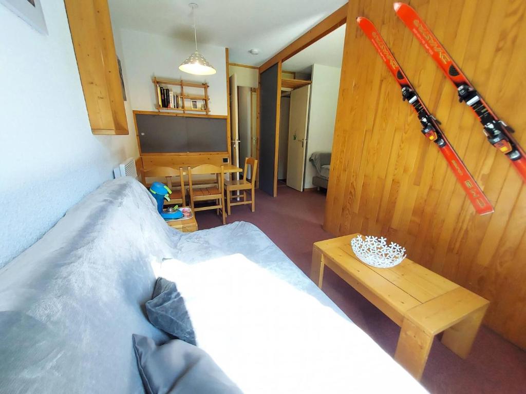 une chambre avec un lit et une table avec des skis au mur dans l'établissement Résidence Pierrer G - PIERRER 10 MAE-6331, à Valmorel
