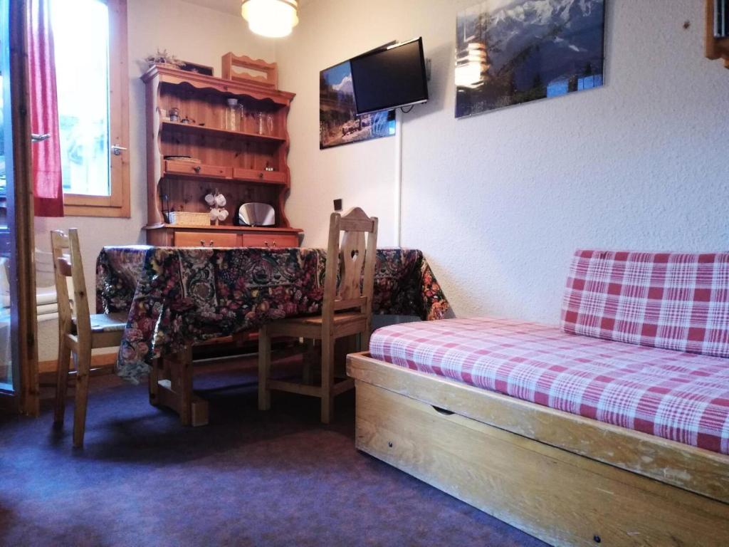 une chambre avec un lit, une table et des chaises dans l'établissement Résidence Cote Soleil G - COTE SOLEIL 41 MAE-6321, à Valmorel