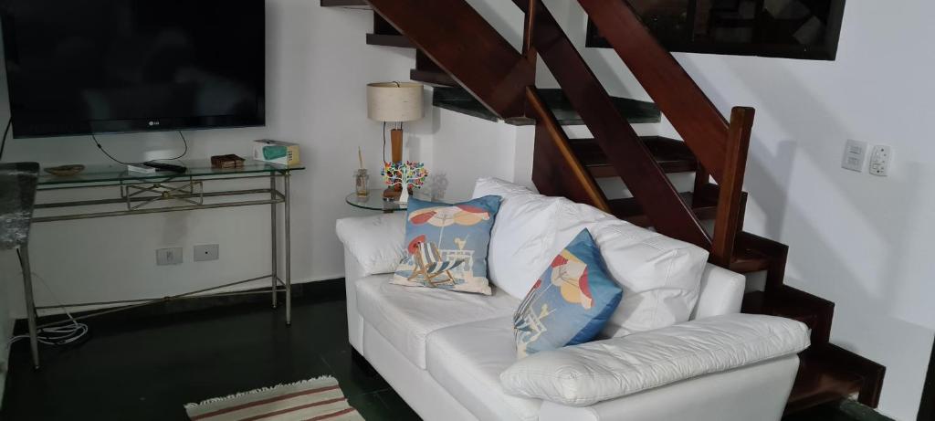 a white couch with two pillows on it in a living room at Casa em Villagio na Riviera in Riviera de São Lourenço