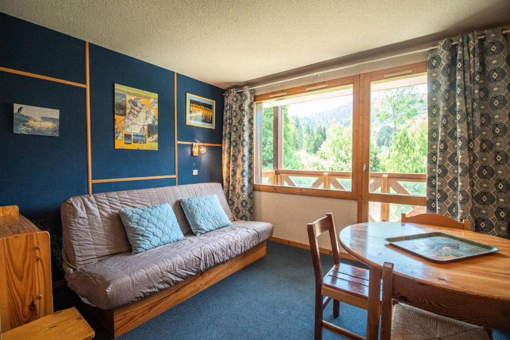 un salon avec un canapé et une table dans l'établissement Résidence Cheval Blanc G - CHEVAL BLANC C63 MAE-6421, à Valmorel