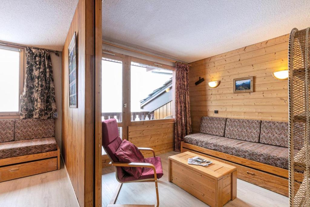 Cette chambre comprend un canapé, une chaise et une table. dans l'établissement Résidence Roche Combe G - ROCHE COMBE 37 MAE-6461, à Valmorel