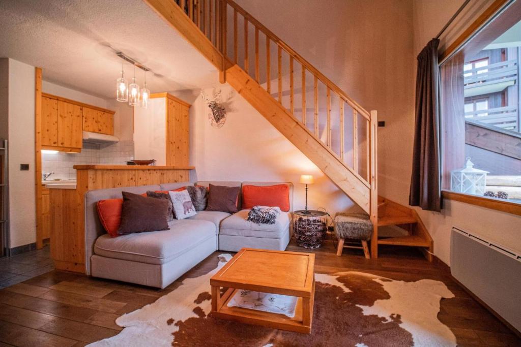 un salon avec un canapé et un escalier dans l'établissement Résidence Cotes G - COTES 40 MAE-6531, à Valmorel