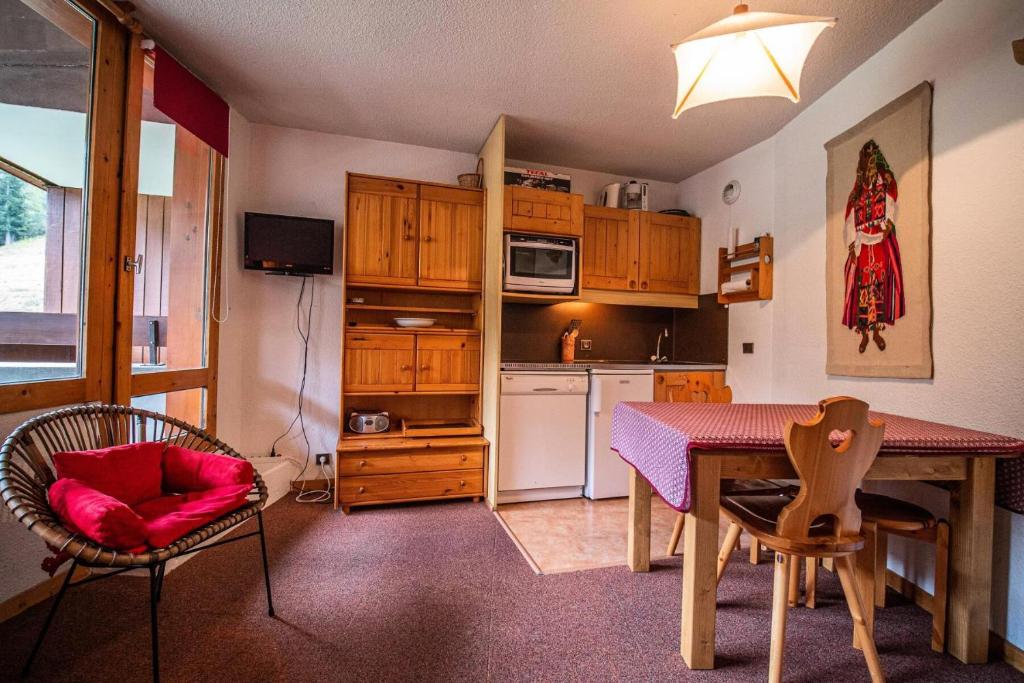 une cuisine avec une table et des chaises ainsi qu'une salle à manger dans l'établissement Résidence Mucillon G - MUCILLON 29 MAE-6701, à Valmorel