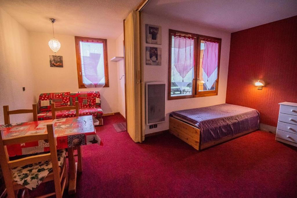 une chambre avec un lit, une table et des chaises dans l'établissement Résidence Cachette G - CACHETTE 29 MAE-6771, à Valmorel