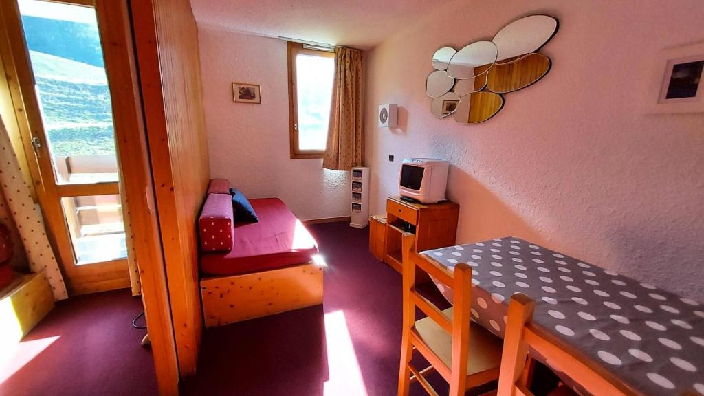 Cette petite chambre comprend une table, un lit et un bureau. dans l'établissement Résidence Gollet G - GOLLET 38 MAE-6831, à Valmorel