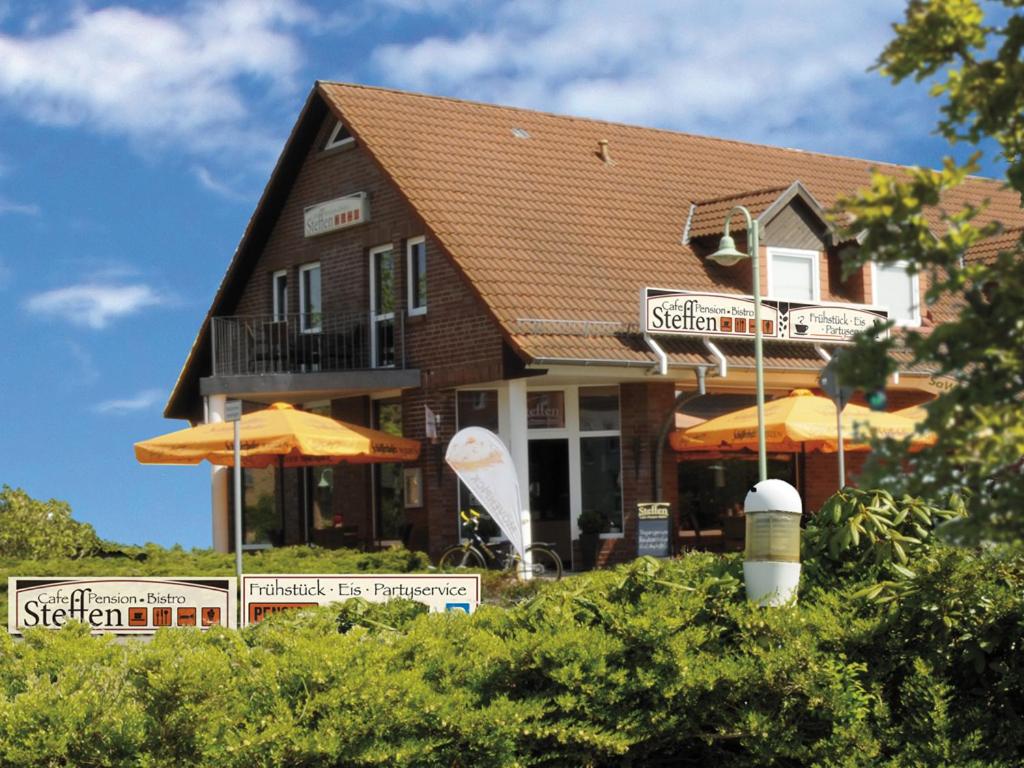 ein Haus mit Schildern davor in der Unterkunft Café Pension Steffen in Sanitz