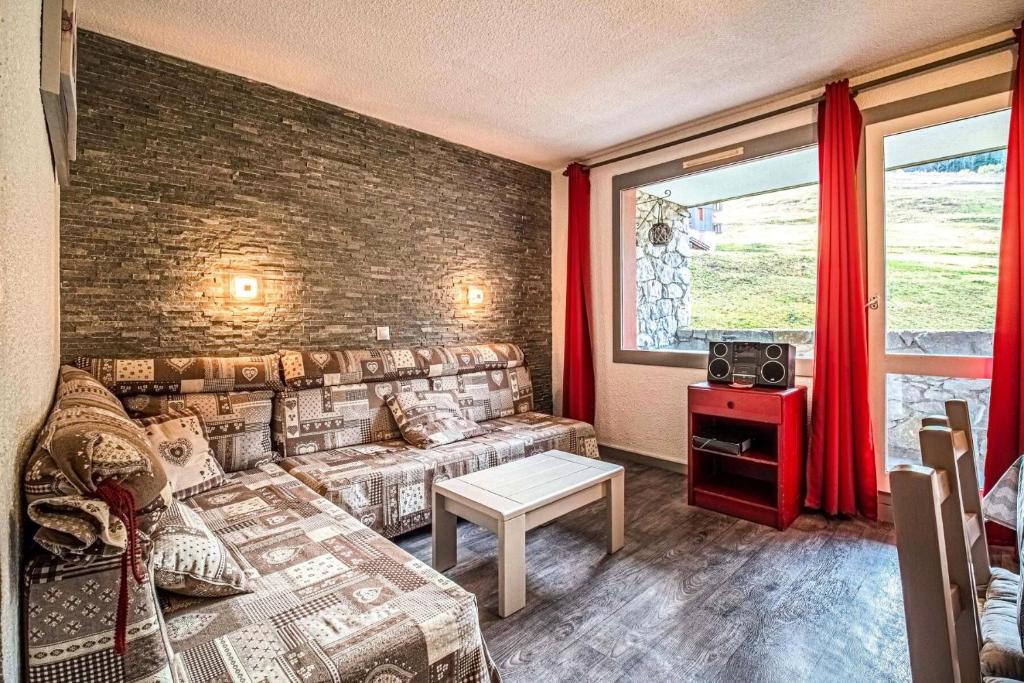 un salon avec un canapé et une fenêtre dans l'établissement Résidence Portail G - PORTAIL 42 MAE-7031, à Valmorel