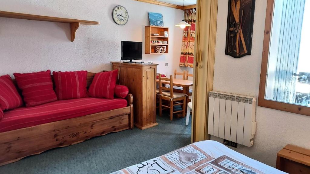 un salon avec un canapé rouge et une table dans l'établissement Résidence Caillou G - CAILLOU 16 MAE-7051, à Valmorel