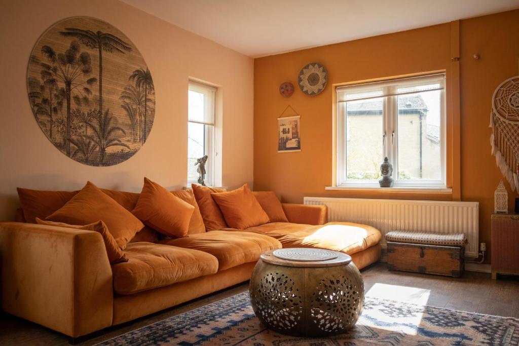 ein Wohnzimmer mit einem braunen Sofa und einem Fenster in der Unterkunft Peak District Home from Home! in Grindleford Bridge