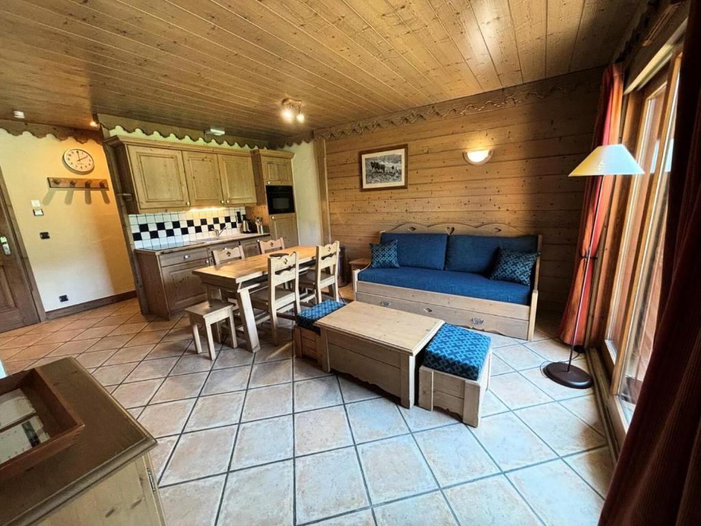 un salon avec un canapé bleu et une table dans l'établissement Les Chalets Du Gypse - LES CHALETS DU GYPSE A02 MAE-2291, à Saint-Martin-de-Belleville