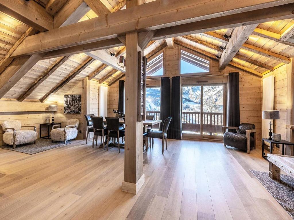 - un salon avec des plafonds en bois, une table et des chaises dans l'établissement Les Chalets Du Gypse - LES CHALETS DU GYPSE A05 MAE-3471, à Saint-Martin-de-Belleville