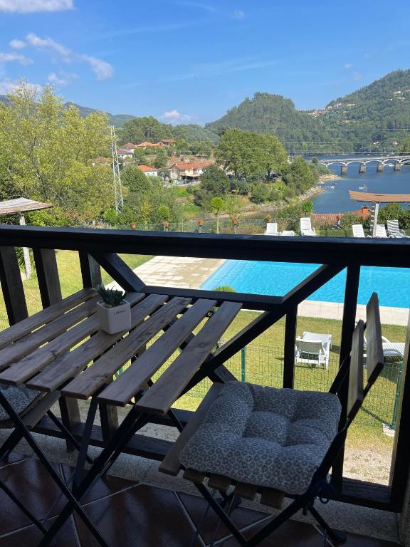 a wooden bench on a balcony with a view of the water at Gerês Pichoses Camping - Quartos in Geres