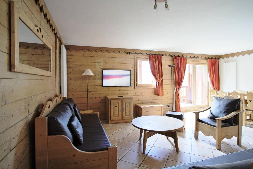 un salon avec un canapé et une table dans l'établissement Les Chalets Du Gypse - LES CHALETS DU GYPSE B02 MAE-3521, à Saint-Martin-de-Belleville
