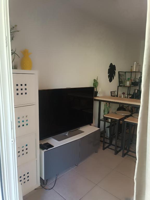 - un salon avec une télévision sur un meuble blanc dans l'établissement Charmant T2 proche centre ville, à Narbonne