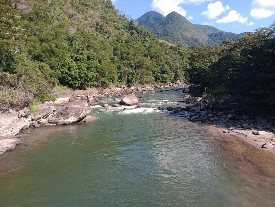 a river with rocks in the middle of a mountain at Chalé no Sana - Equilíbrio e Descanso in Sana