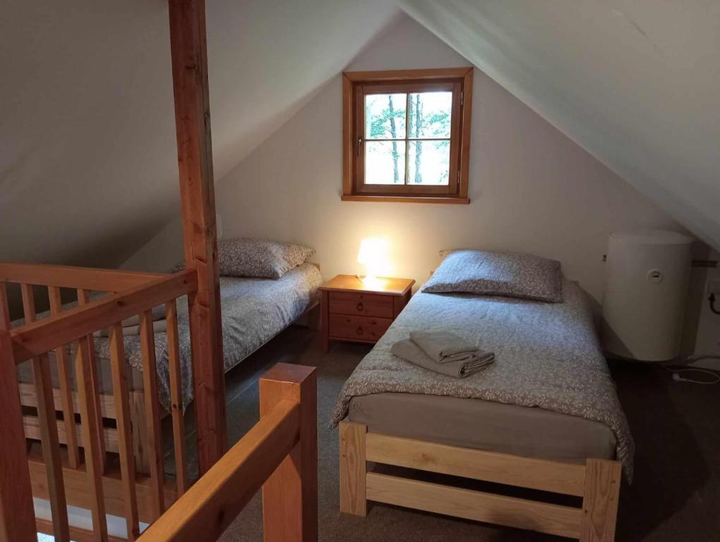 a attic room with two beds and a window at Villa Stare Osieczno in Stare Osieczno