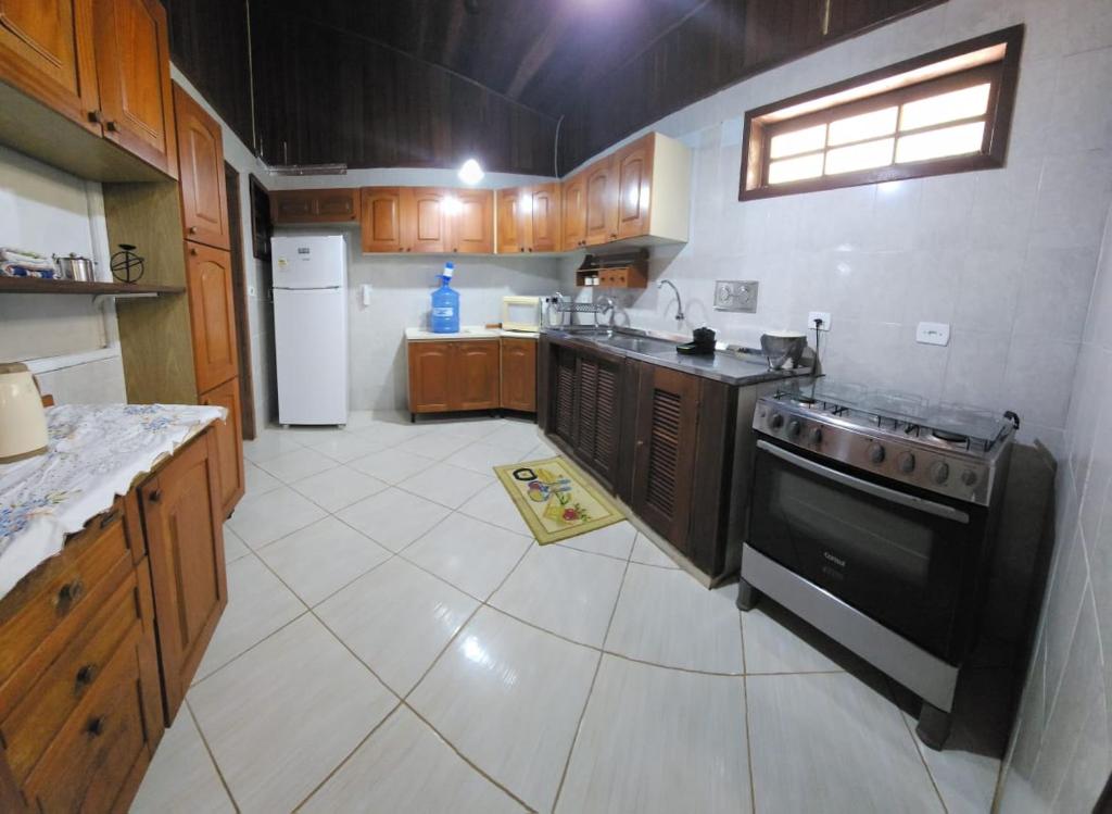 a large kitchen with a stove and a sink at Casa do Amaral 2 in Angra dos Reis