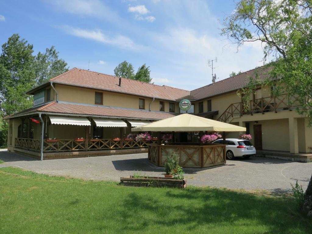 un bâtiment avec un grand parapluie devant lui dans l'établissement Guest House Meat Heads Pub, à Komárno
