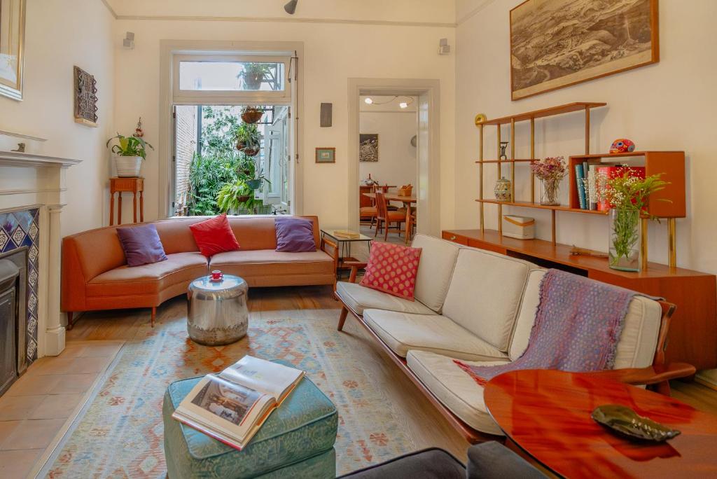 Una sala de estar con un sofá y una chimenea. en Casa Chapulín-Mexican Eclectic Home in Roma Norte, en Ciudad de México