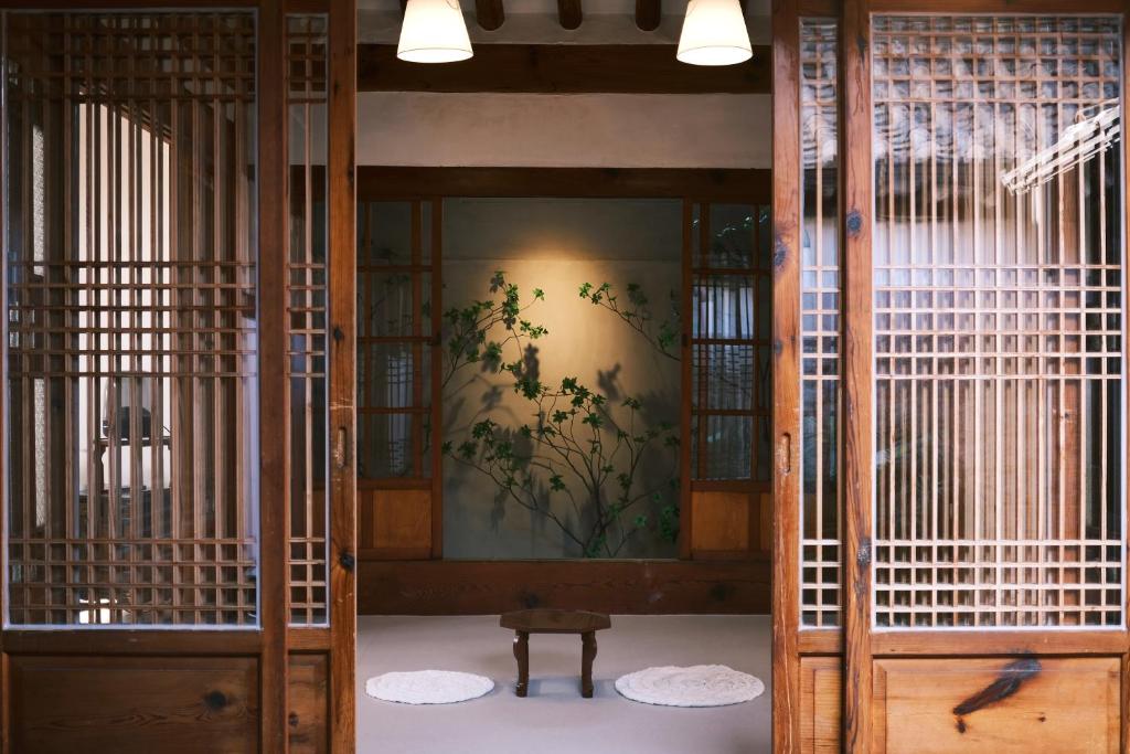 a room with wooden doors and a wall with a painting at Unwadang Private Luxury Hanok House in bukchon in Seoul