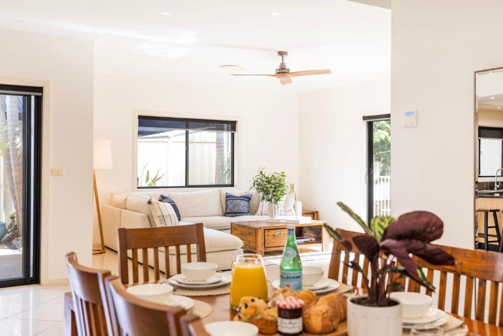 a living room with a table and chairs and a couch at The Atrium by Experience Jervis Bay in St Georges Basin
