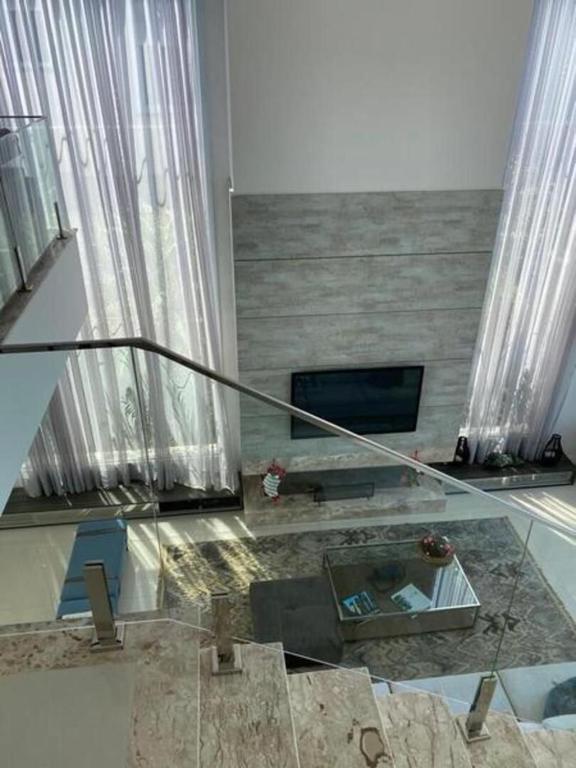 a living room with a fireplace and a glass floor at Casa de Luxo no Condomínio Enseada in Xangri-lá