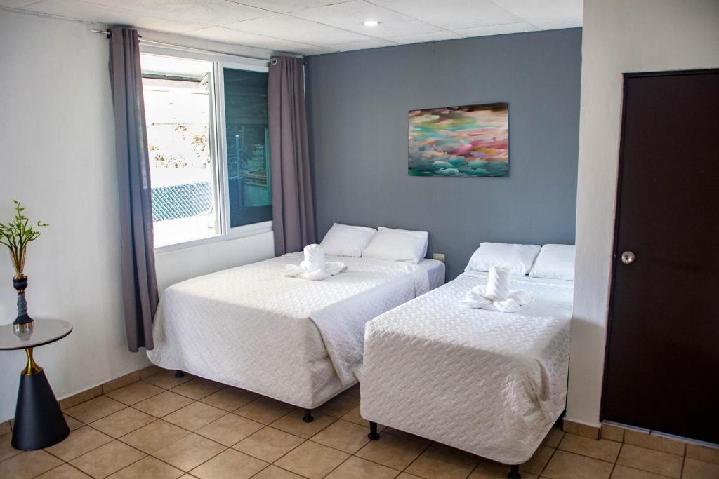 Una habitación de hotel con dos camas y una ventana. en Hotel Casa Manantiales, en Mexicanos