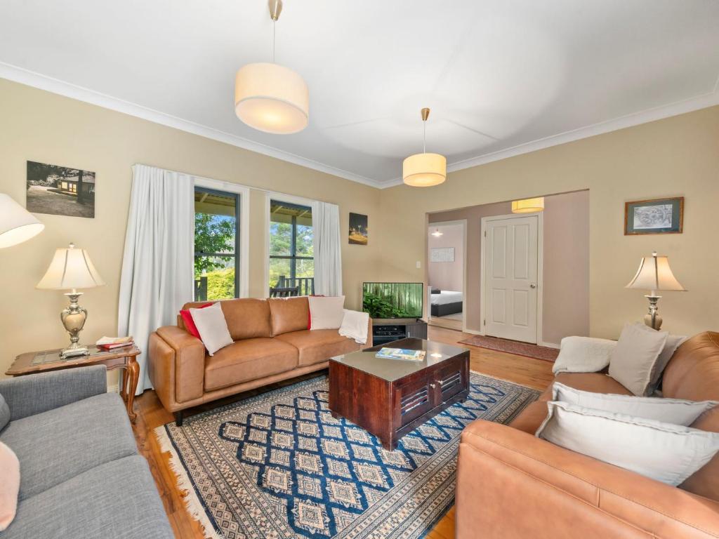 a living room with couches and a tv at Scenic Cottage in Katoomba