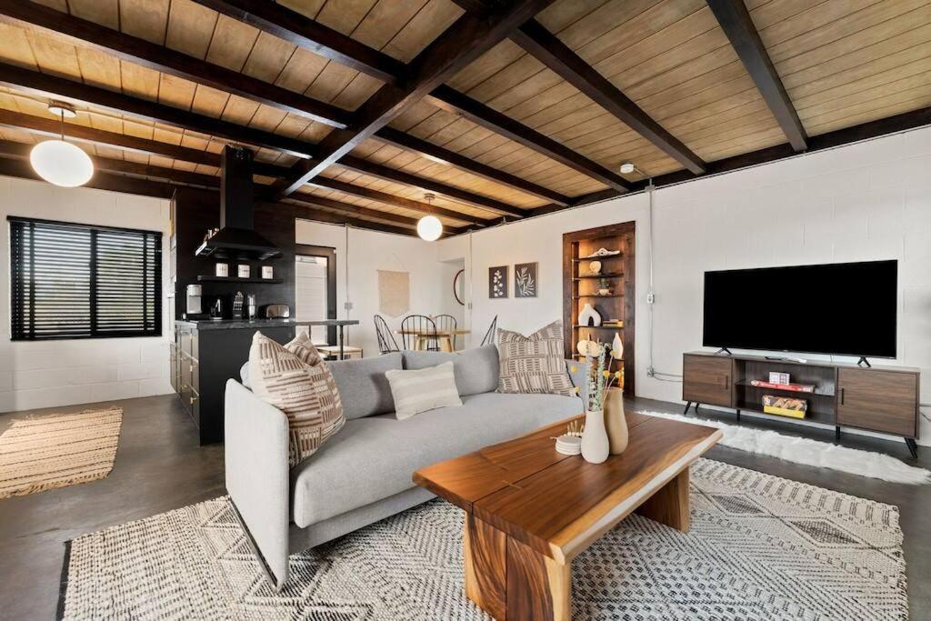 Una sala de estar con un sofá y un televisor. en The Desert Serenity-Stunning views-Pool-Spa-BBQ, en Yucca Valley