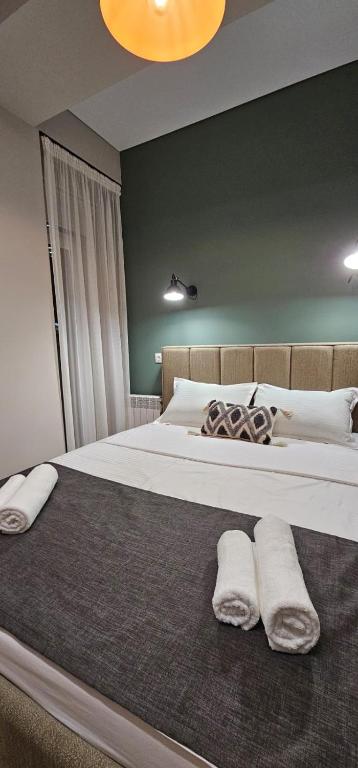 a bedroom with a large bed with two towels on it at LUX-Апартаменты Manhattan style на Тохтарова in Ustʼ-Kamenogorsk