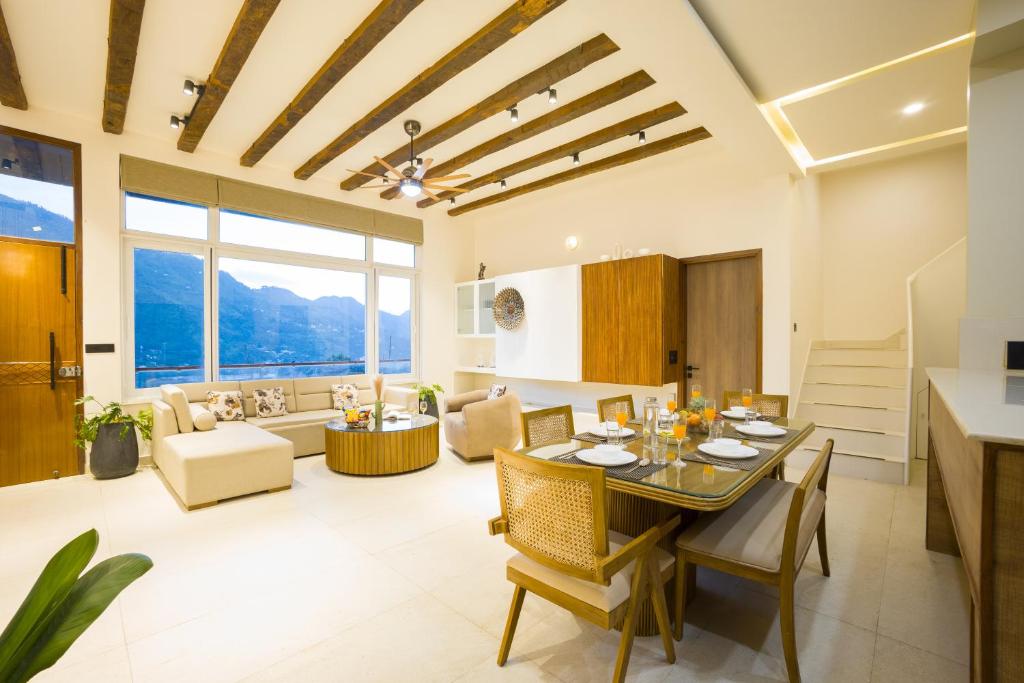 a dining room and living room with a table and chairs at ELIVAAS Signature 4 BHK with Balcony & Terrace - Antarmann Casa Nova in Bhīm Tāl
